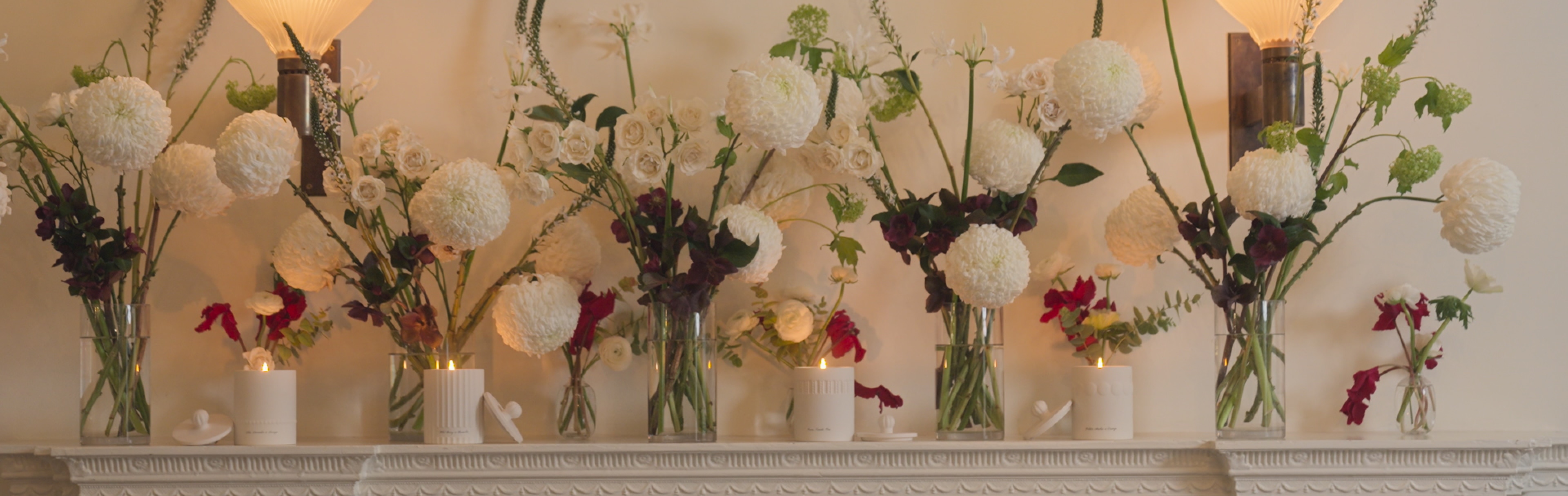 Jo Malone London Townhouse Candles Collection on mantelpiece with flower bouquets