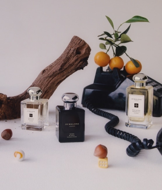 50ml and 100ml Colognes surrounded by wood and oranges