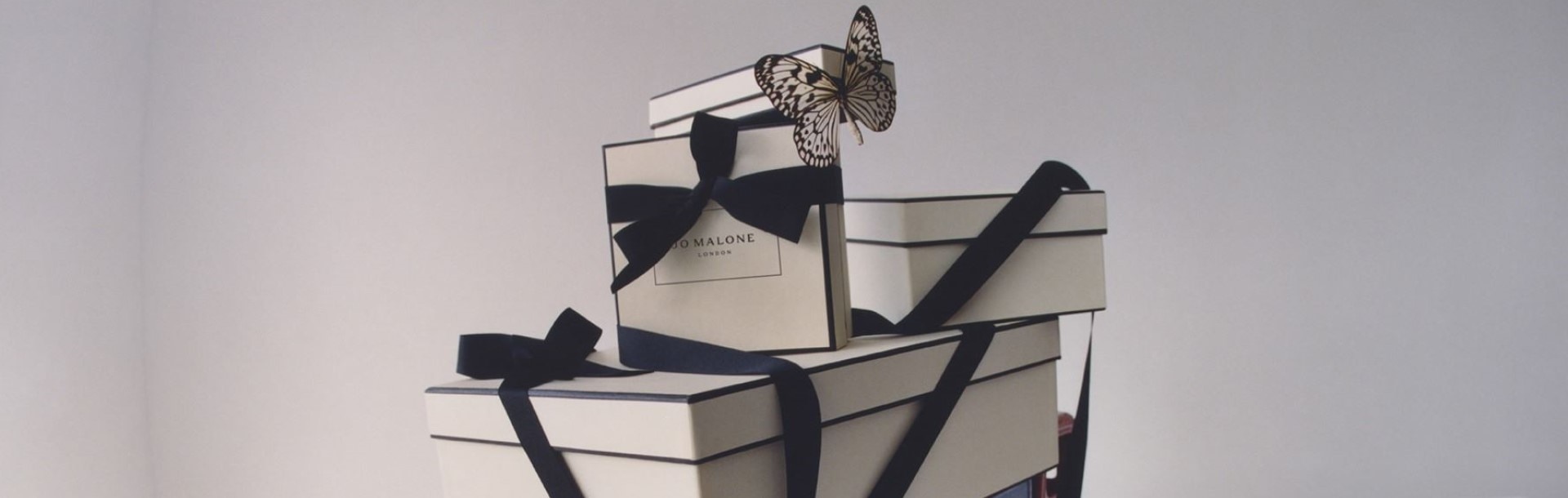 Jo Malone London's iconic black & cream gift boxes, beautifully tied with black ribbon on top of a blue toy truck